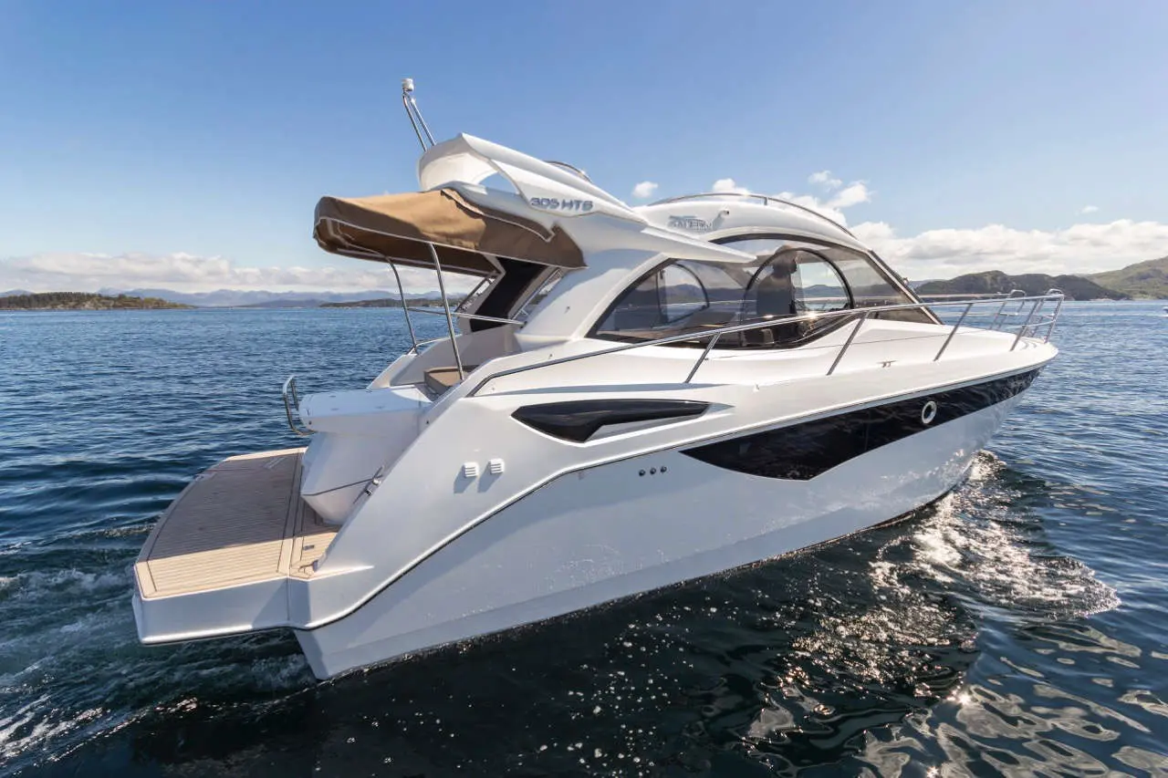 Modern motor yacht 305 HTS gliding on calm waters, showcasing sleek design and spacious rear deck under a clear blue sky.
