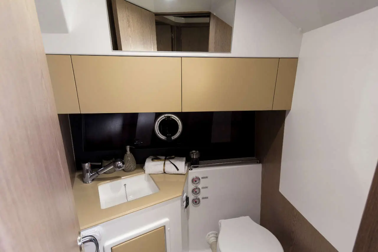 Modern bathroom with a stylish sink, mirror, towels, and toiletries in a compact design.