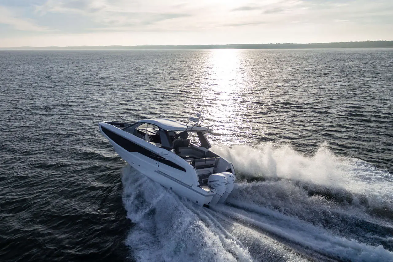 Luxury motor yacht gliding across shimmering water at sunset, showcasing sophisticated design and powerful performance.