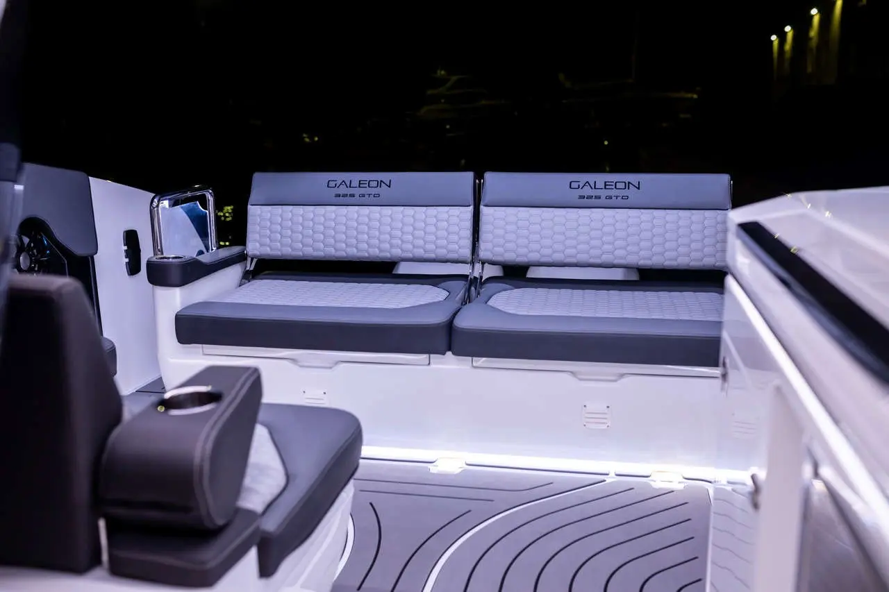 Luxury Galeon 325 GTO boat seating area with stylish grey upholstery, illuminated floor and sleek design.