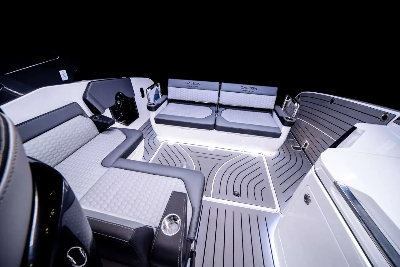 Stylish boat interior with modern seating, featuring gray and black cushions, illuminated flooring, and the 