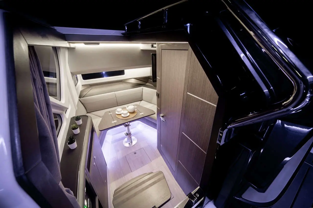 Stylish cabin interior with a grey seating area, a table set for tea, and modern lighting enhancing the space's elegance.