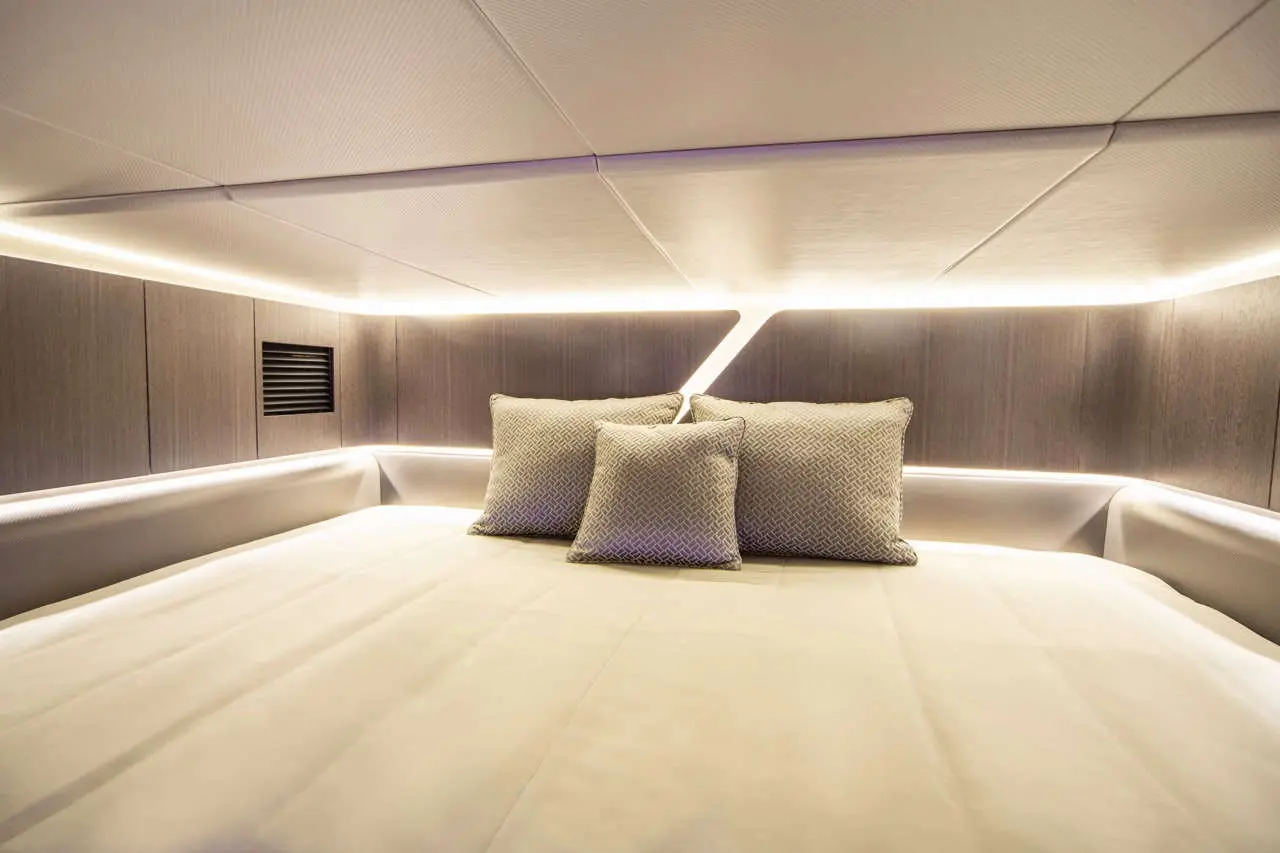 Modern bed with plush pillows, ambient lighting, and smooth walls in a stylish interior setting.