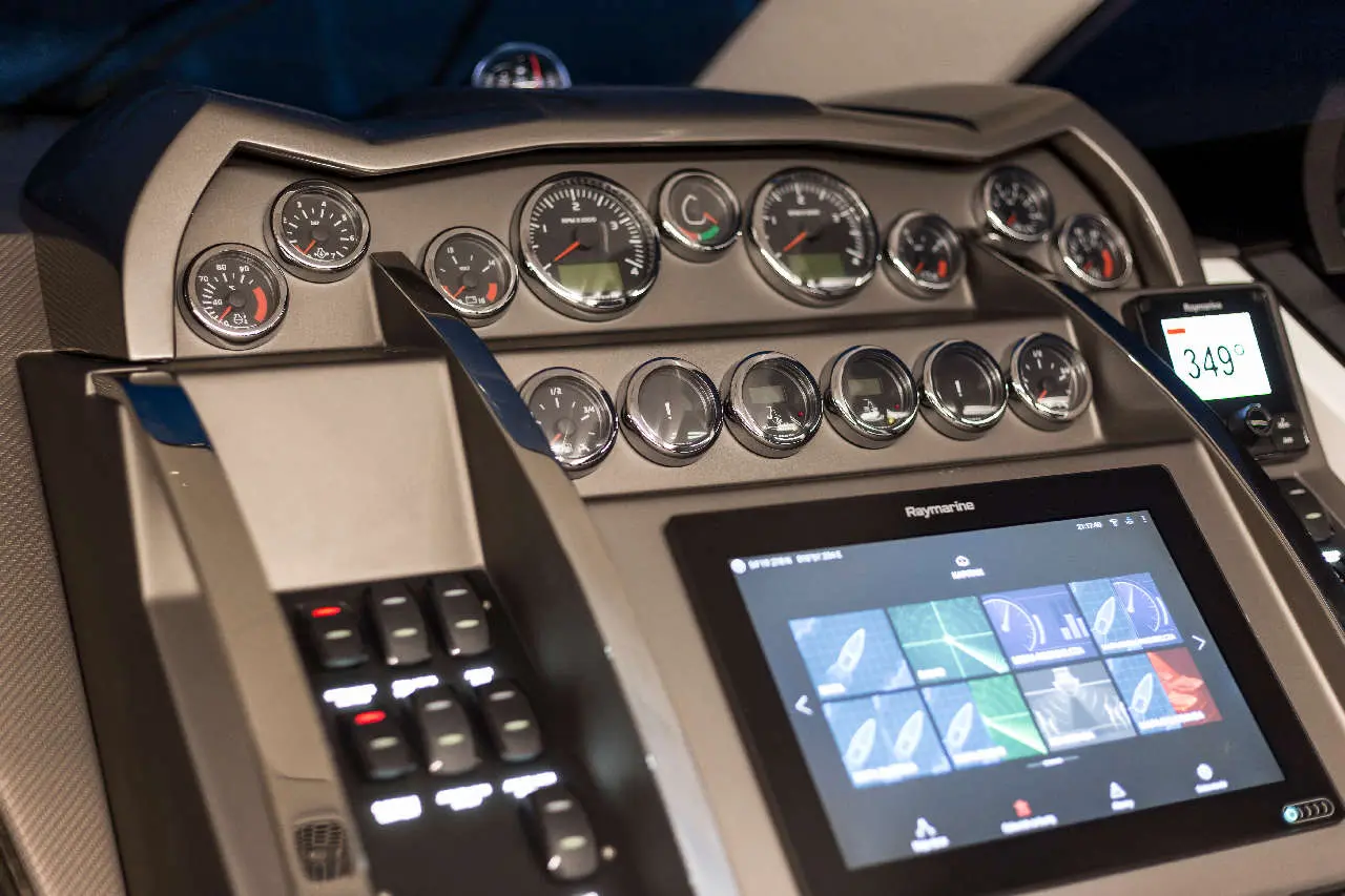 High-tech boat dashboard featuring digital screens and analog gauges, displaying various navigational and performance data.