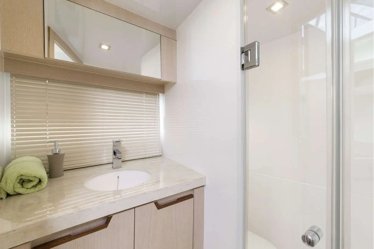 Modern bathroom featuring a sink, a mirror, a towel, and a shower enclosure with a glass door.