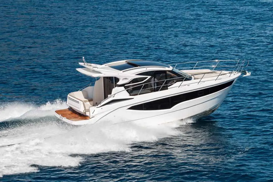 A sleek white motorboat cruising through blue waters, leaving a spray of waves behind. Ideal for luxury outings.