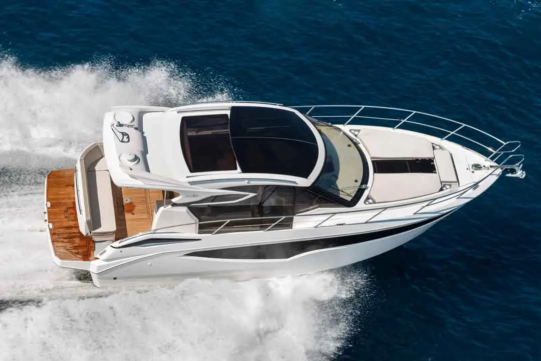 A sleek white motorboat with a modern design gliding through deep blue water, creating a wake behind it.