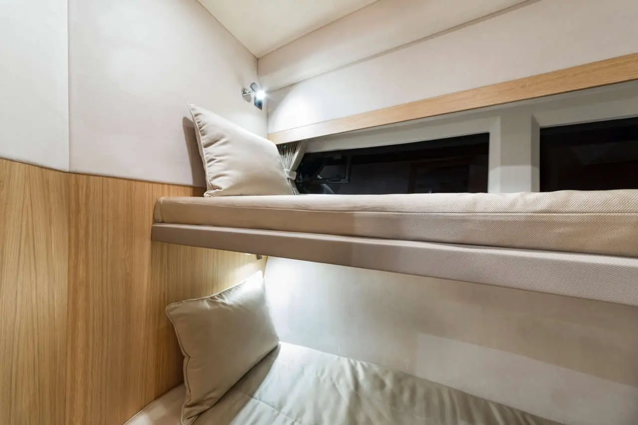 Bunk beds in a modern setting with soft cushions, warm wood accents, and soft lighting, creating a cozy atmosphere.