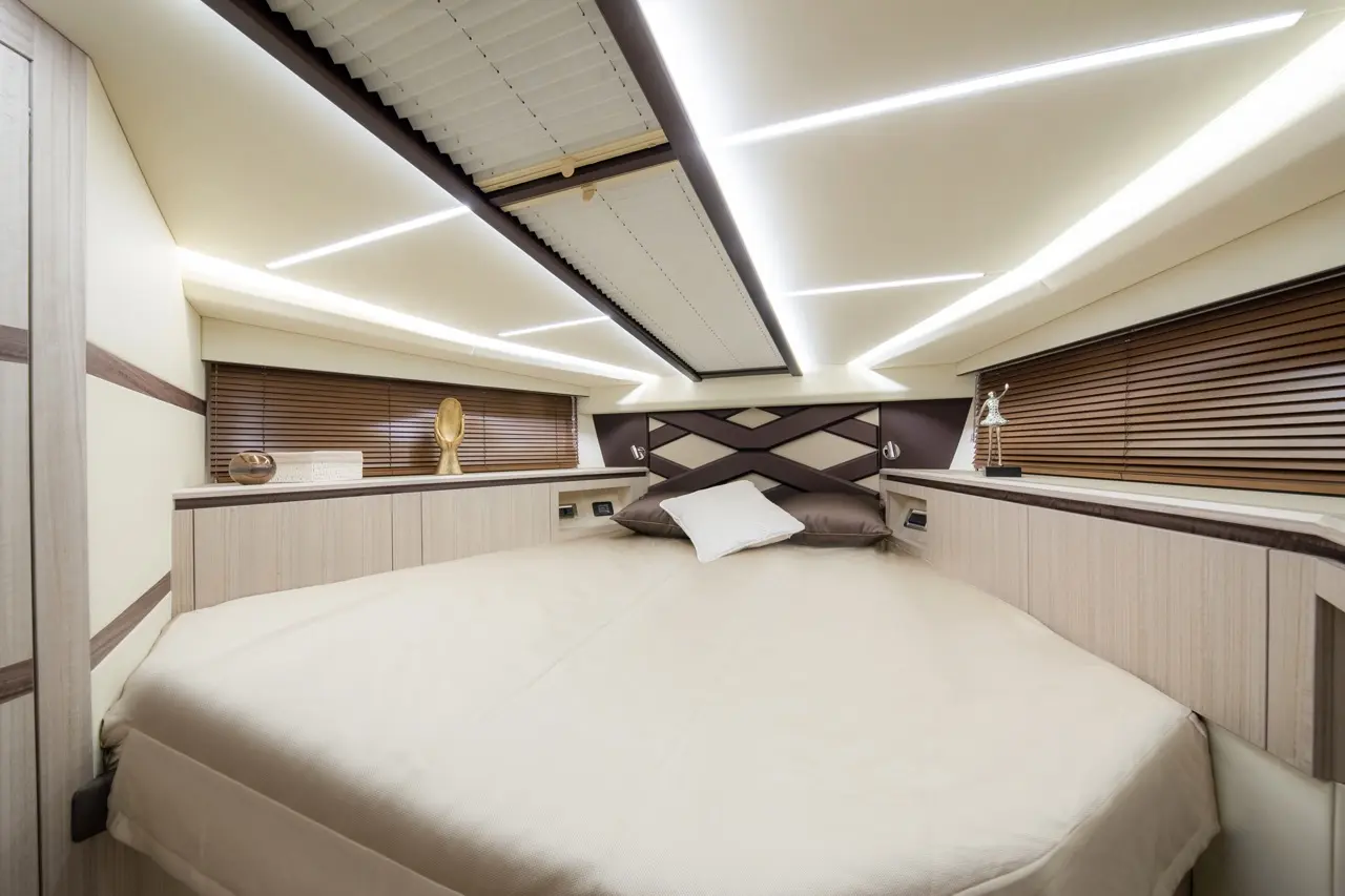 Luxurious bedroom with a large round bed, stylish decor, ambient lighting, and elegant furnishings in a yacht interior.