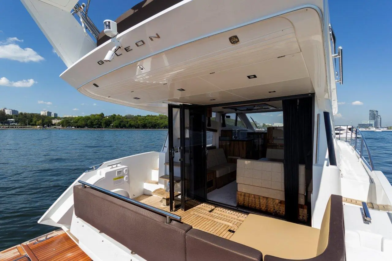 Luxury yacht Galleon with an open lounge area, showcasing sleek design and waterfront views against a clear blue sky.