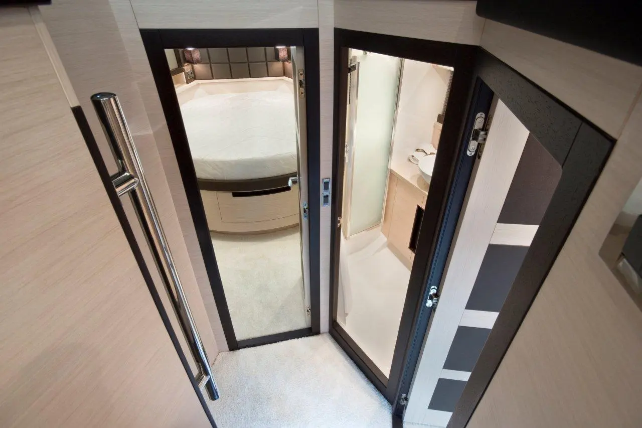 Interior view of a luxury cabin featuring two doors: one leading to a bathroom, the other to a stylish sleeping area.
