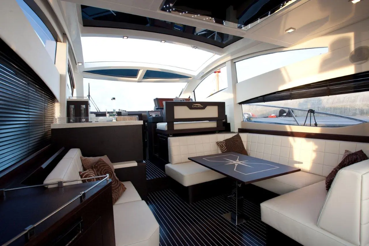 Luxury yacht interior showcasing a spacious seating area, modern decor, and a sleek table with a star design.