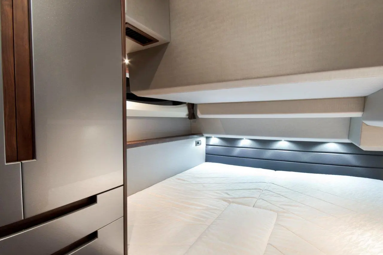 Modern bedroom interior featuring a sleek bed, wooden accents, and subtle lighting, emphasizing a minimalistic design.