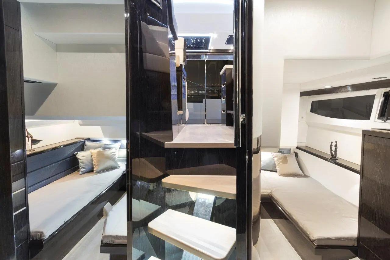 Modern yacht interior featuring sleek seating, stylish decor, and spiral staircase leading to upper levels.
