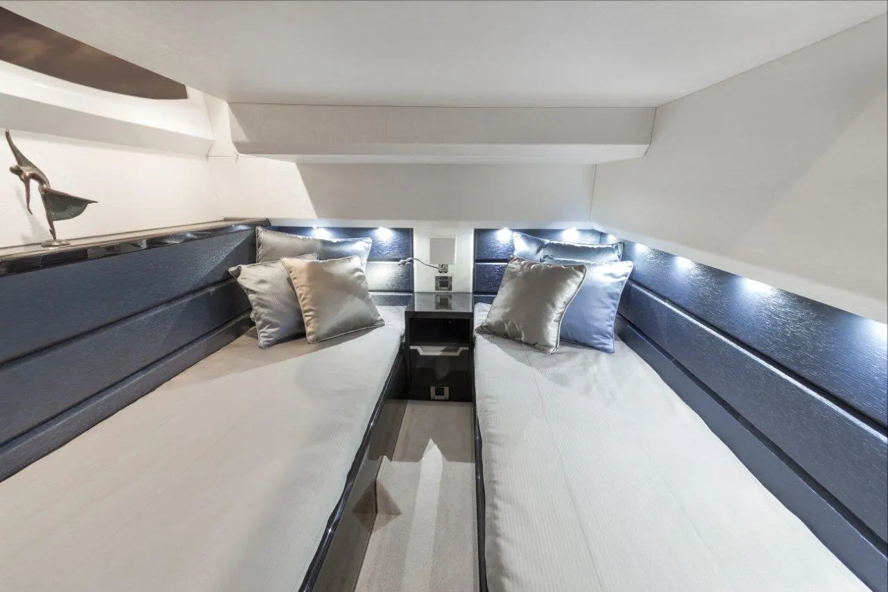 Modern twin cabin with two beds, plush pillows, and soft lighting, showcasing elegant design and a serene atmosphere.