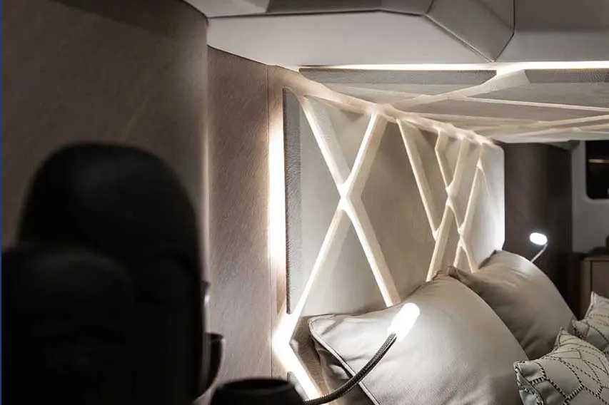 Modern bedroom featuring a stylish lighted headboard, decorative pillows, and a sleek design for cozy ambiance.