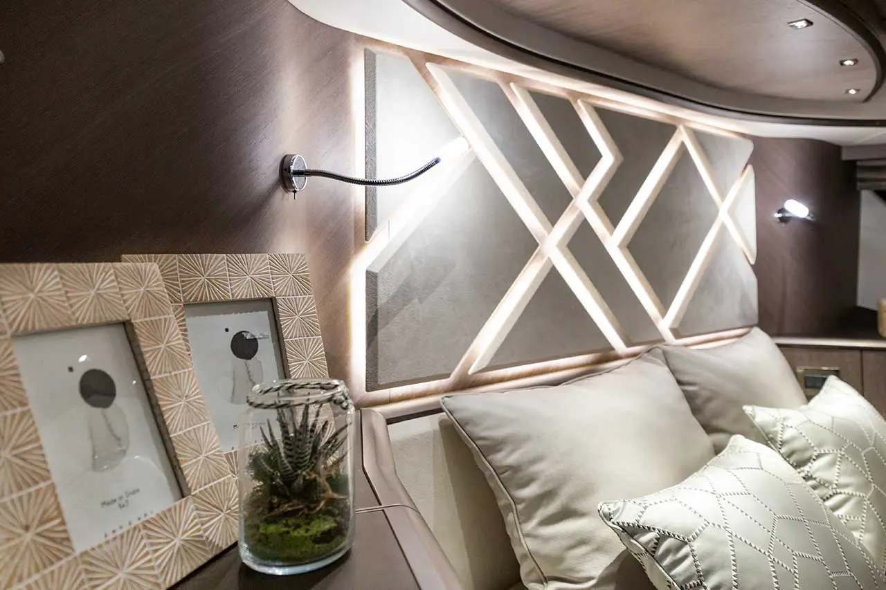 Modern interior with geometric wall decor, framed artwork, a glass terrarium, and plush pillows on a cozy sofa.