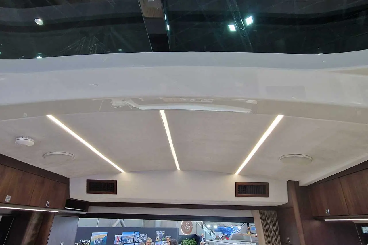 Interior view showcasing a modern yacht's ceiling with recessed lighting, smooth finish, and dark wood accents.