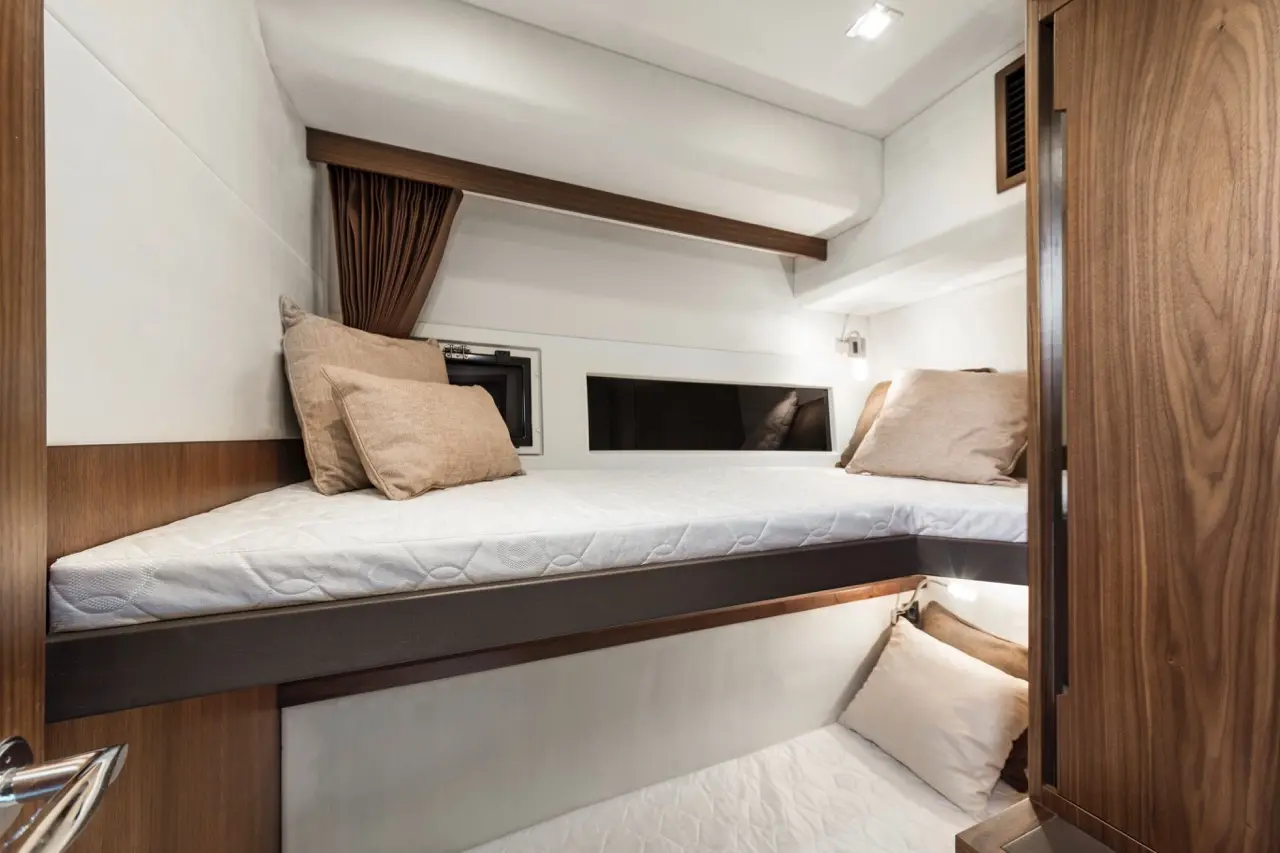 Bunk beds in a modern cabin, featuring soft pillows, wood accents, and warm lighting, creating a cosy atmosphere.
