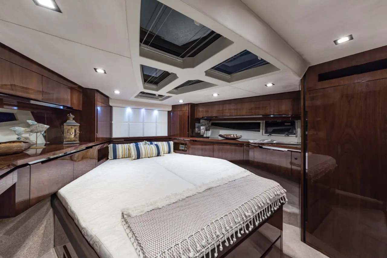 Luxurious yacht interior featuring a spacious cabin with a large double bed, wooden cabinetry, and stylish skylights.