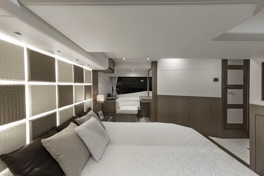 Modern bedroom with twin beds, stylish wall panels, and elegant lighting; features light wood accents and a sleek design.