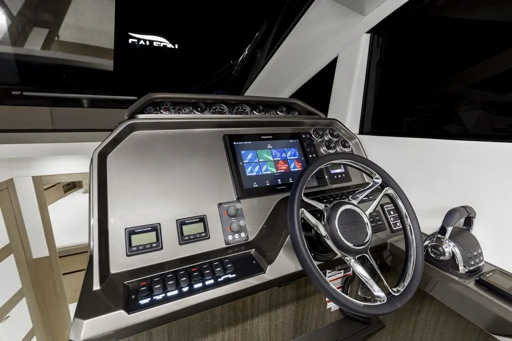 Luxury yacht control panel featuring a sleek steering wheel, digital screens, gauges, and modern control buttons.