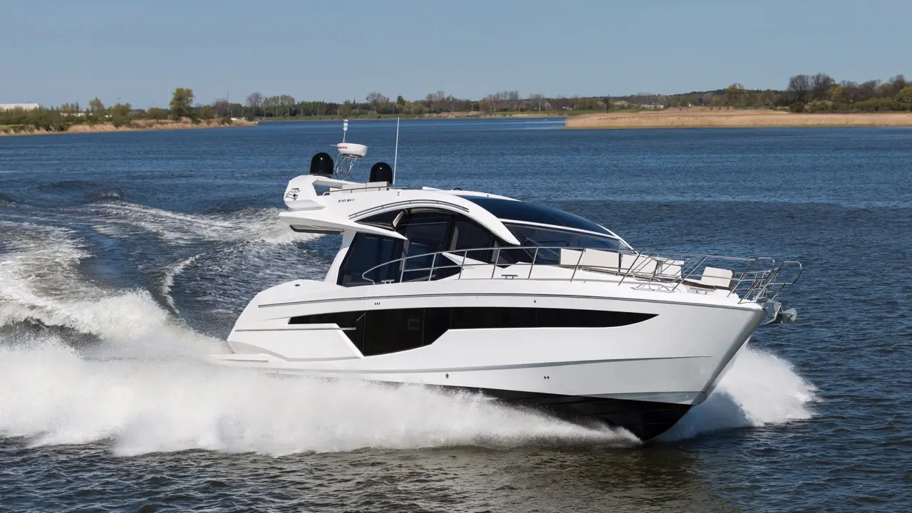 A sleek white luxury yacht cruising on calm water, leaving a wake, against a backdrop of green trees and blue sky.