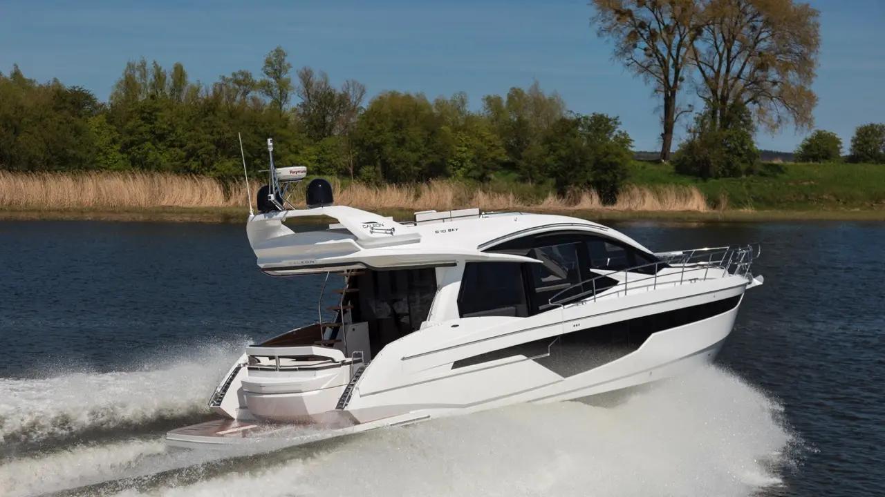 Galeon 520 Sky motorboat cruising on a river, surrounded by greenery, showcasing sleek design and dynamic water splashes.