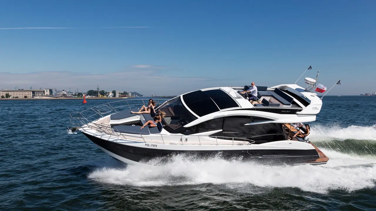 A sleek white motorboat with passengers enjoys a sunny day on the water, leaving a dynamic wake against a blue sky.