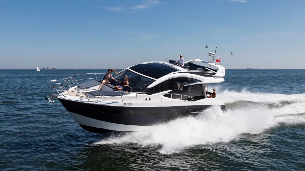 A stylish black and white motorboat speeds through the ocean, with people relaxing on deck under a clear blue sky.