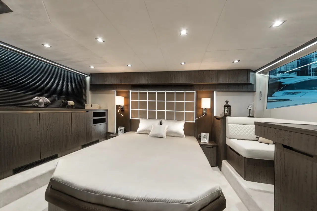 Luxurious yacht bedroom featuring a large bed, modern decor, and ambient lighting with a sleek design and ocean view.