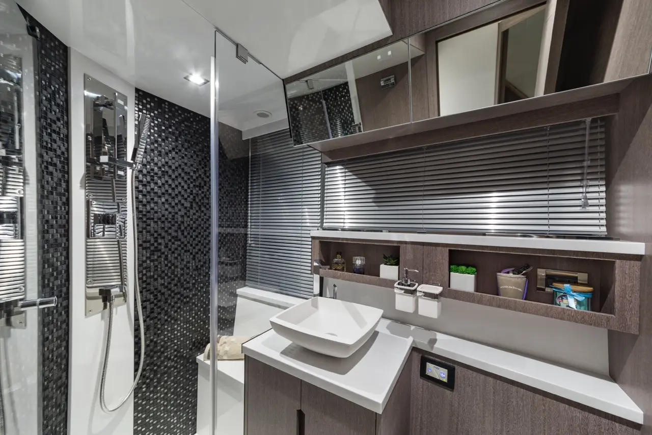 Modern bathroom featuring a walk-in shower, sleek sink, wooden cabinetry, and decorative plants against a stylish backdrop.