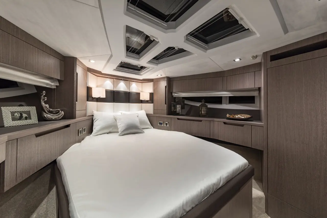 Modern yacht bedroom featuring a large bed, soft lighting, decorative accents, and skylights for natural light.
