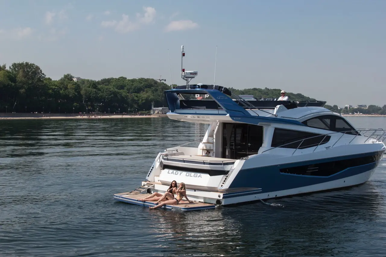 Two women relax on a swim platform of the yacht 
