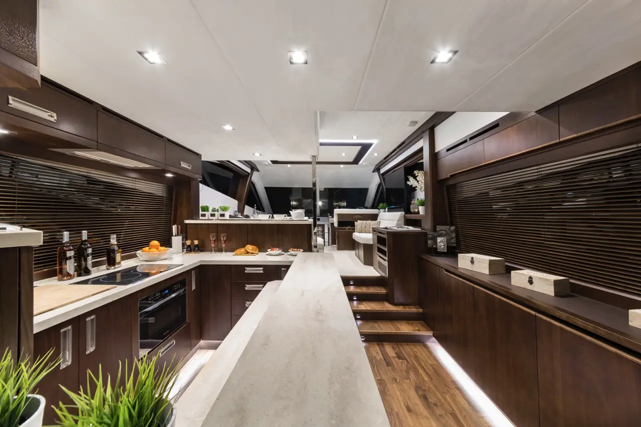 Modern yacht interior featuring a sleek kitchen with dark wood cabinetry, a stone countertop, and stylish decor.