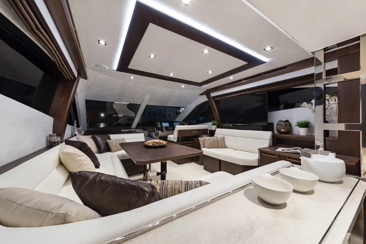 Modern yacht interior featuring elegant furnishings, a spacious seating area, and ambient lighting with sleek cabinetry.