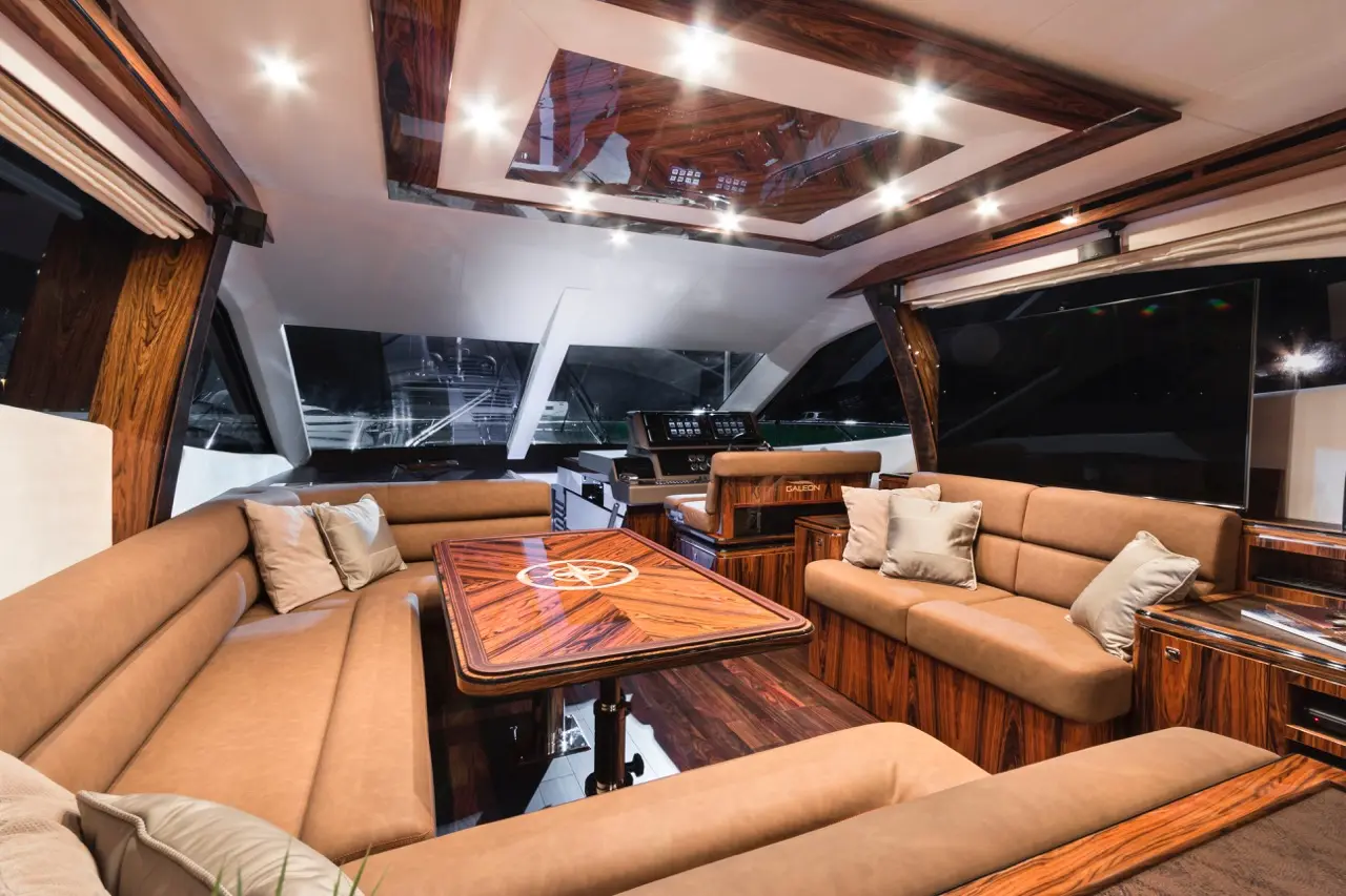 Luxurious yacht interior featuring polished wood, leather seating, and a modern navigation console with ambient lighting.