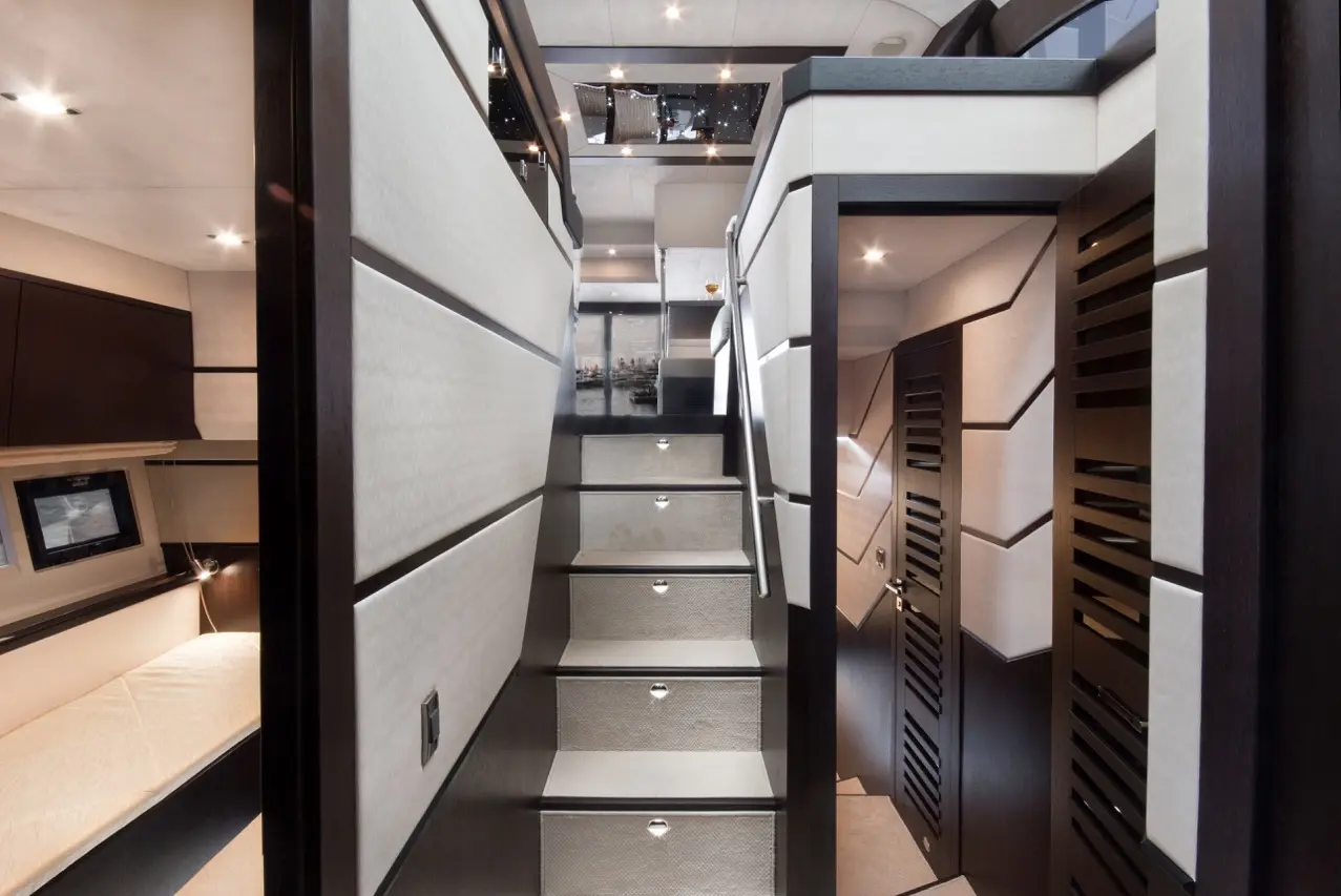 Modern interior of a yacht, featuring a staircase, sleek wood panels, and a stylish design with accent lighting.