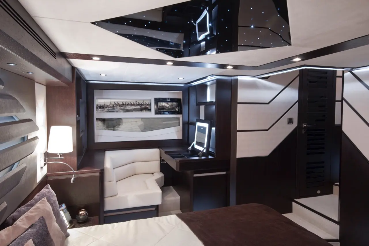 Luxury yacht interior featuring modern design elements, a cozy corner seat, and a sleek work desk with star-patterned ceiling lights.