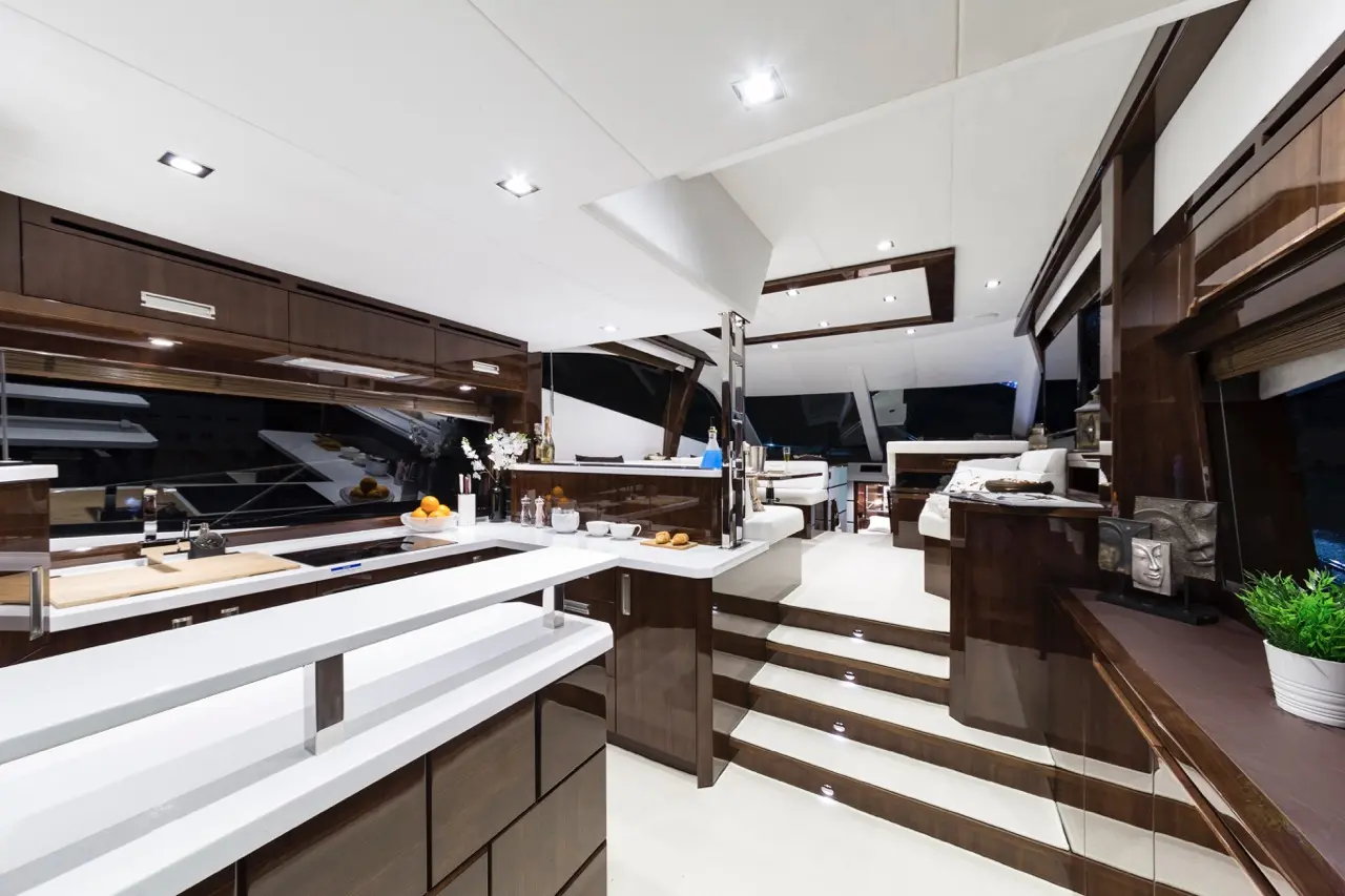 Luxurious yacht interior featuring sleek cabinetry, a spacious kitchen with modern appliances, and elegant seating areas.