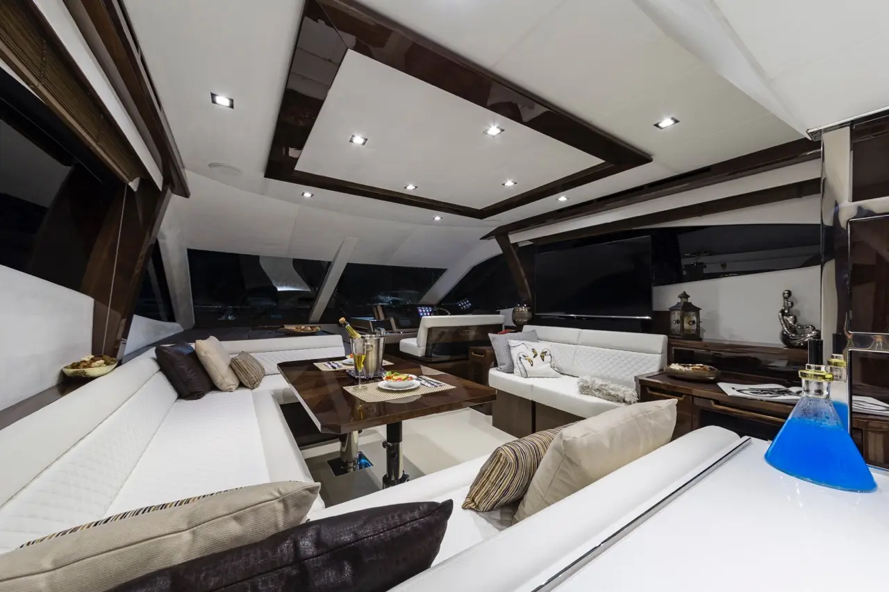 Luxurious yacht interior featuring plush leather seating, a dining area, decorative accents, and blue drinks on a table.