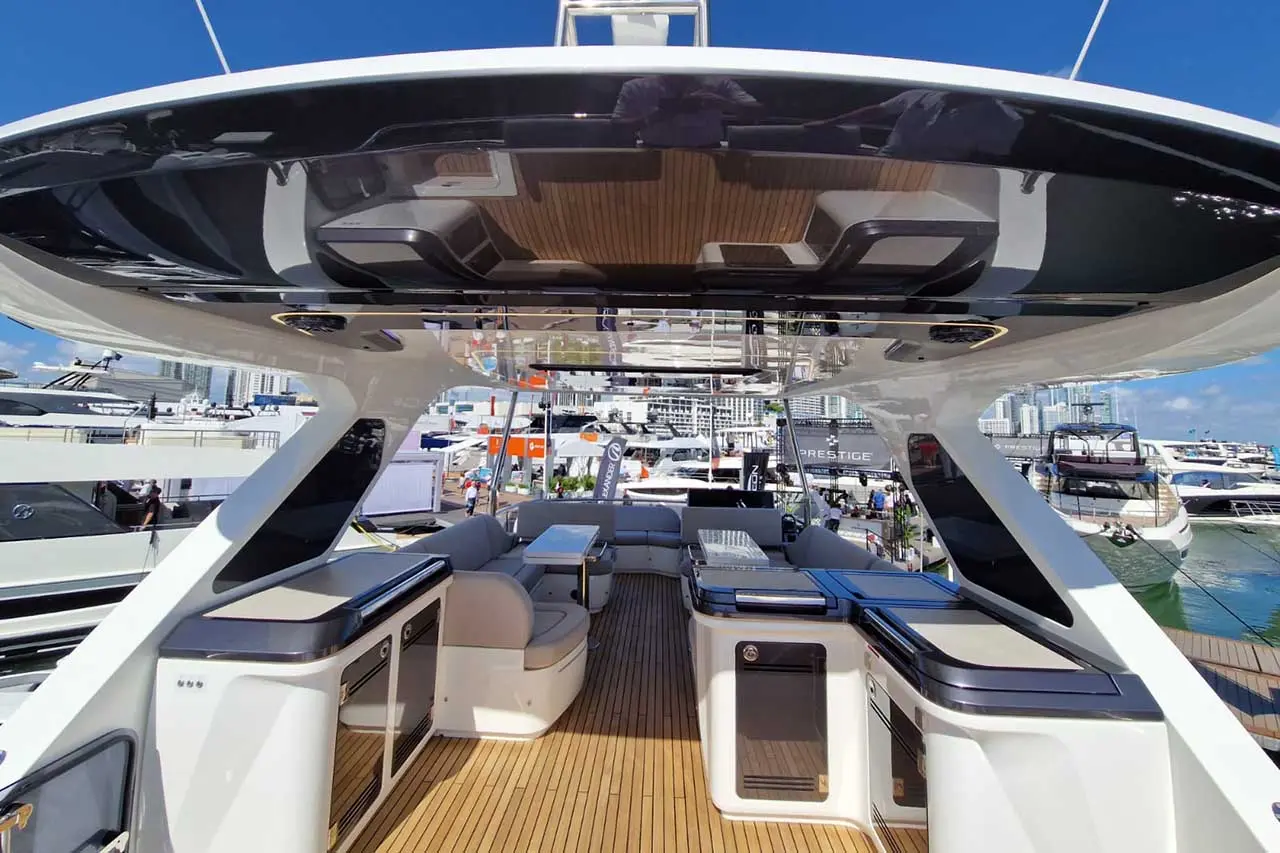 Luxury yacht interior featuring seating, dining tables, and a view of the marina, showcasing modern design and style.