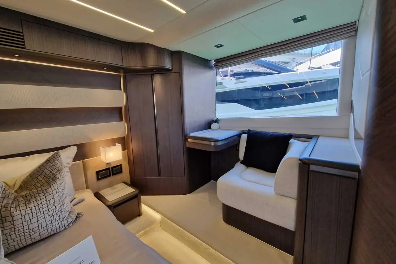 Luxury yacht interior featuring a cozy sleeping area, modern design, large windows, and a chic seating space.