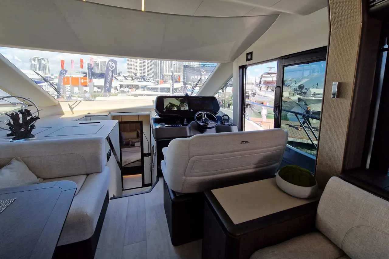 Luxurious yacht interior with a modern helm, plush seating, and views of the marina and city skyline.