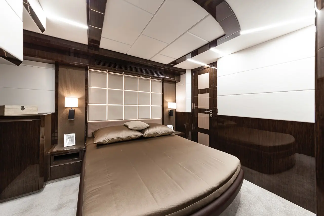 Luxury bedroom featuring a round bed, soft bedding, elegant lighting, and modern decor with a sleek wooden finish.