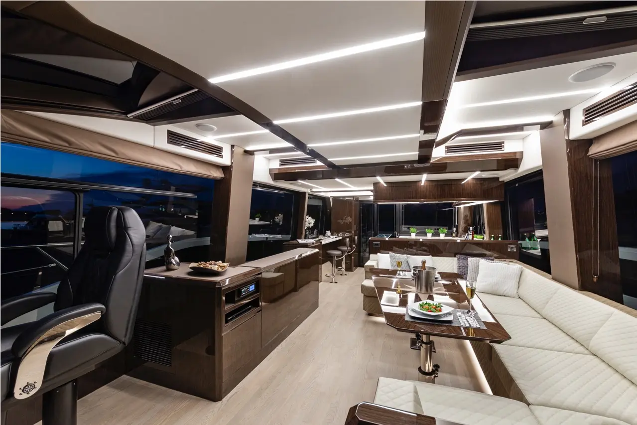 Luxury yacht interior featuring leather seating, modern lighting, and a dining area with plates of food and drinks.
