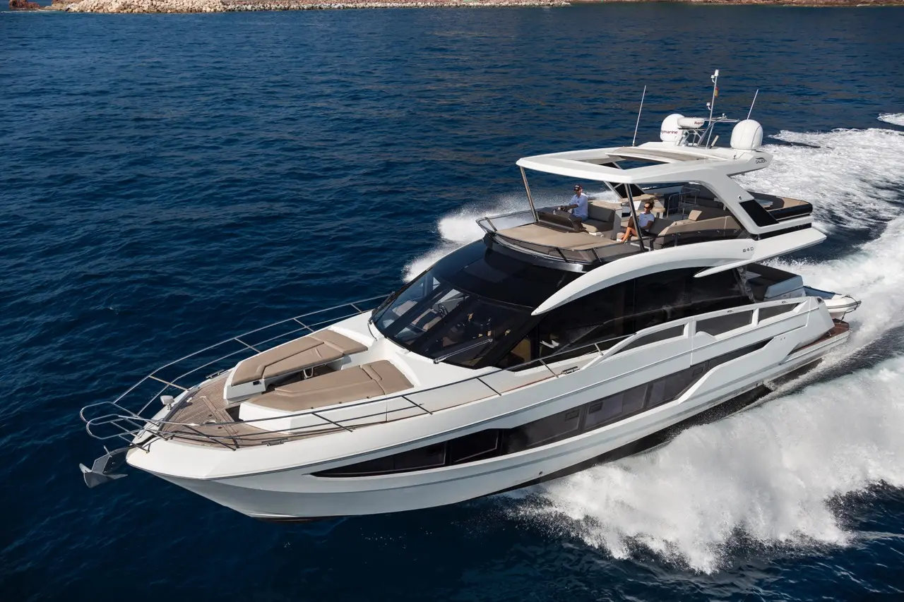 Luxury motor yacht cruising on clear blue water, showcasing sleek design and outdoor seating for relaxing adventures.