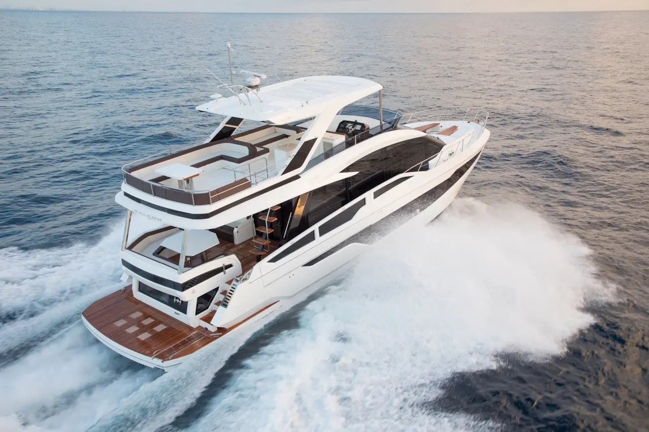 Luxury yacht cruising over waves, featuring multiple decks and sleek design, reflecting a serene ocean backdrop.