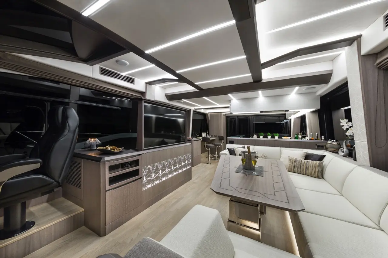 Luxurious RV interior featuring sleek furniture, ambient lighting, a dining table, and stylish decor elements.