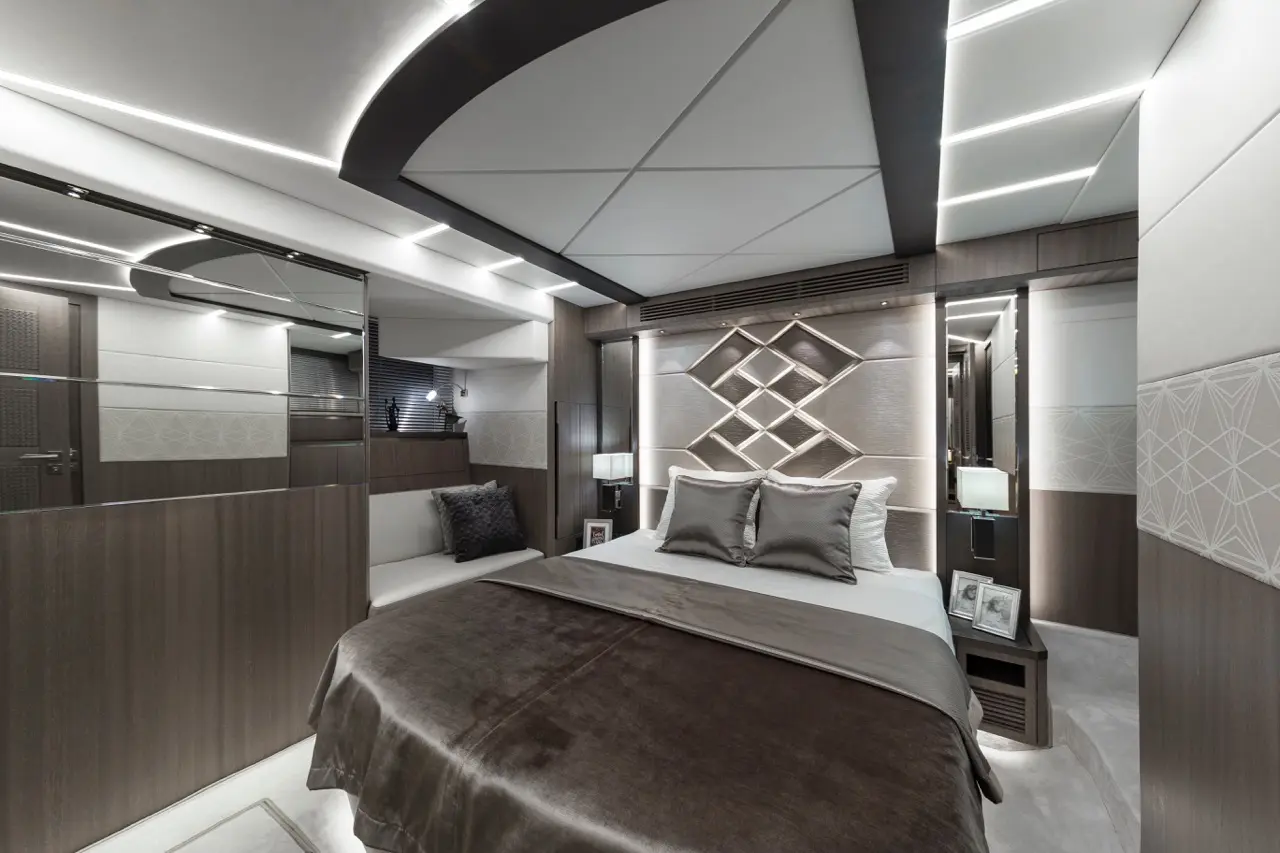Modern bedroom featuring a brown and grey colour scheme, LED lighting, decorative wall patterns, and elegant furnishings.